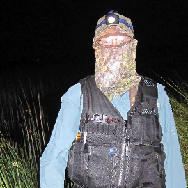 Man in full-body protection and headlamp at night