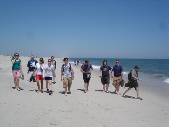 A group of people walking on a beach

Description automatically generated