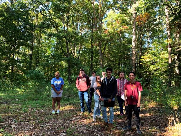 A group of people standing in a forest

Description automatically generated with medium confidence